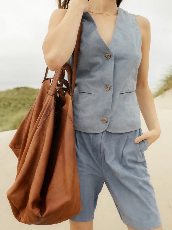 Visuel d'une jeune femme avec un grand sac fourre-tout en cuir souple naturel