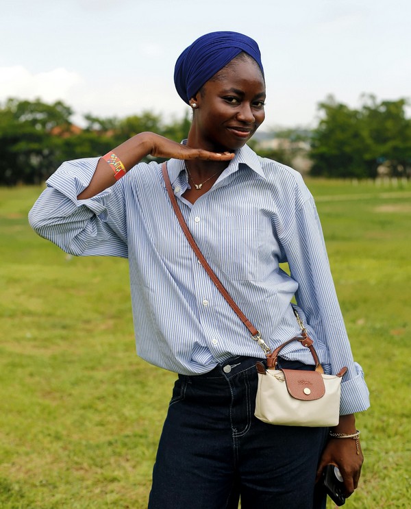 Jeune femme portant un sac pochette cuir en bandoulière
